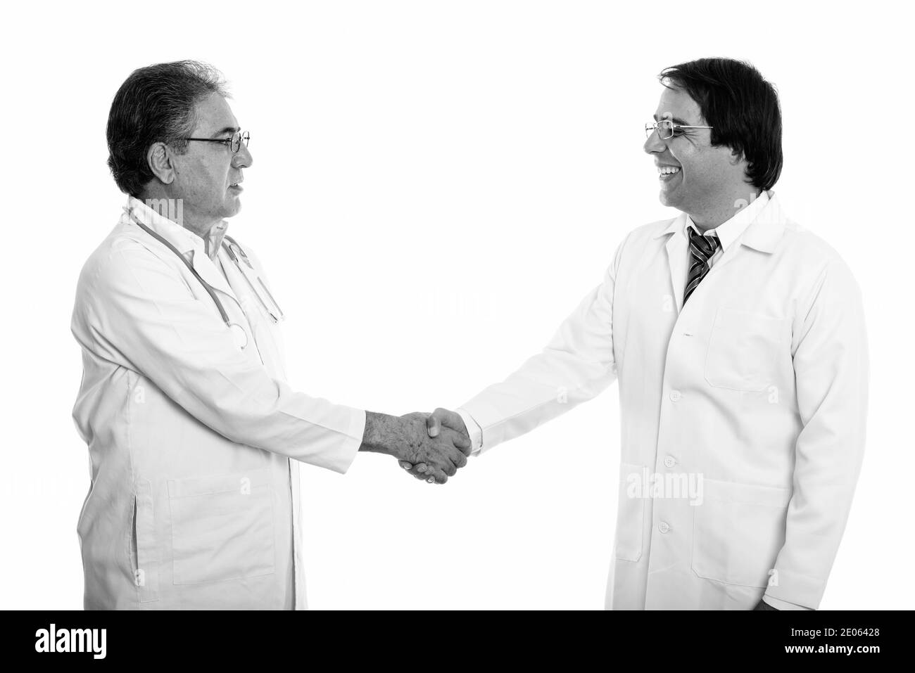 Voir le profil de professionnels jeunes et senior homme médecin persan smiling and shaking hands Banque D'Images