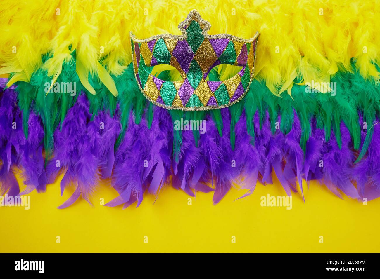 Concept de carnaval de Mardi gras avec masque facial et couleurs de Mardi gras plumes. Banque D'Images