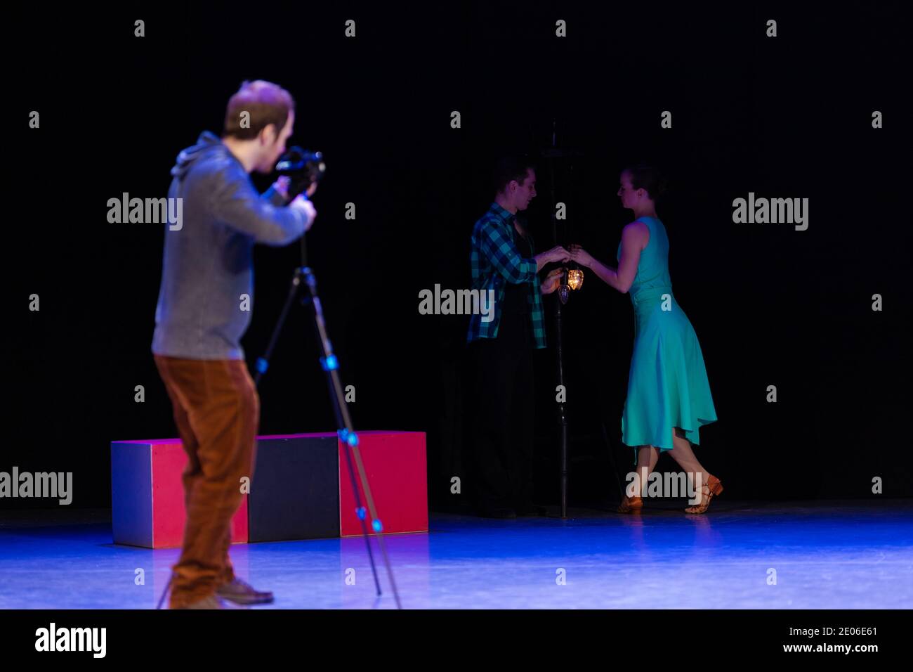 Une paire de danseurs un homme et une femme dansent sur scène et un vidéaste enregistre un clip vidéo et des reportages. Banque D'Images