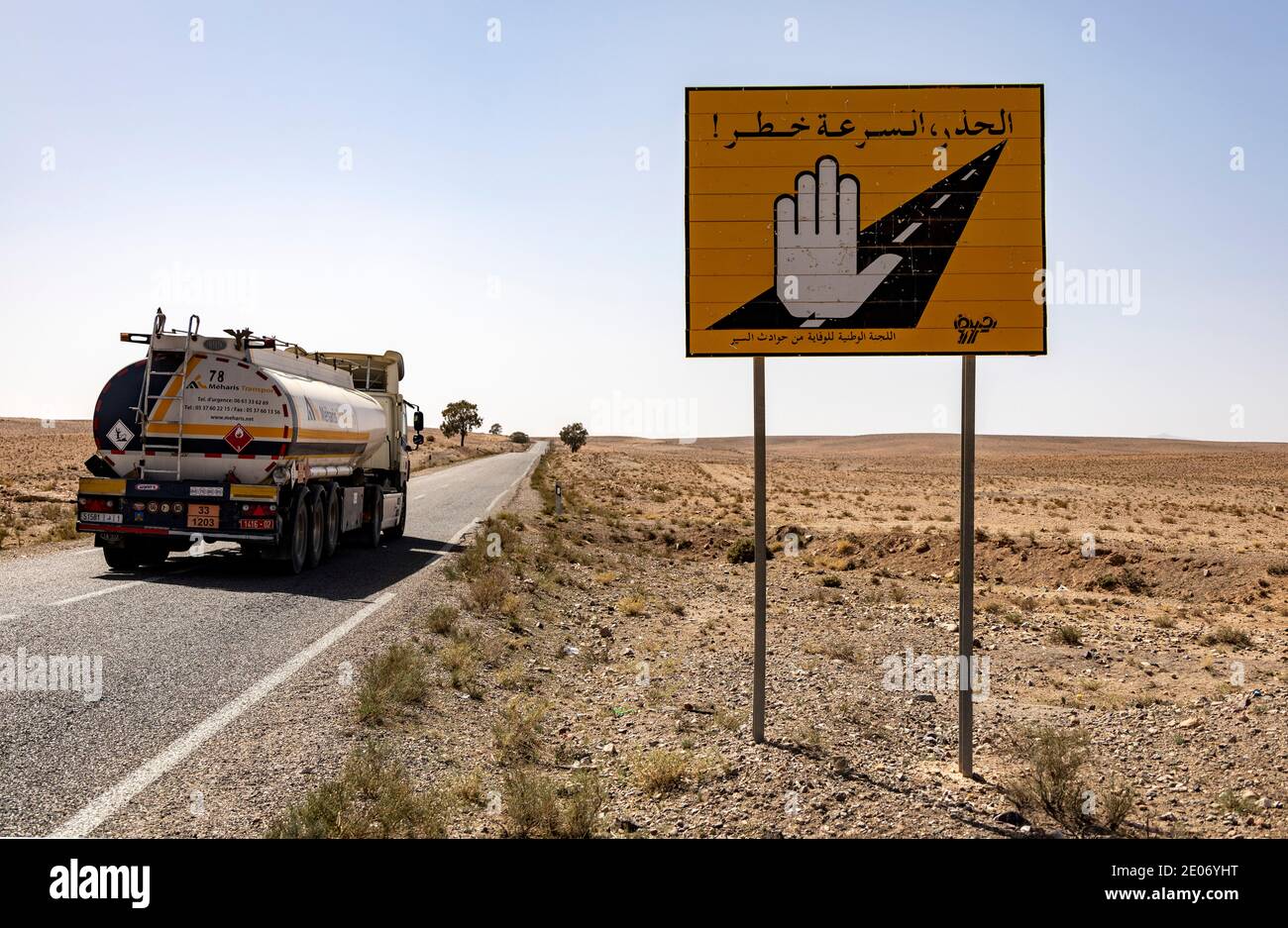 Anti-Atlas, Maroc. 25 février 2020.camion sur une route dans le désert. Panneau de route représentant une main de Fatma (Khamsa) pour se protéger contre l'œil méchant. Banque D'Images