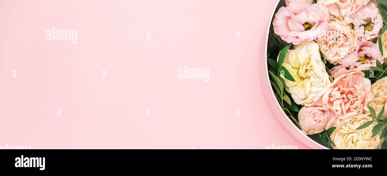 Luxe belles fleurs dans un chapeau rond boîte sur le fond rose avec espace de copie. Cadeau ou cadeau le jour de la Saint-Valentin, 8 mars, fête des mères Banque D'Images