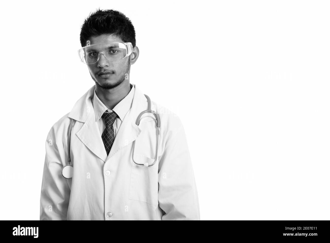 Studio shot of young handsome indien médecin portant des lunettes Banque D'Images