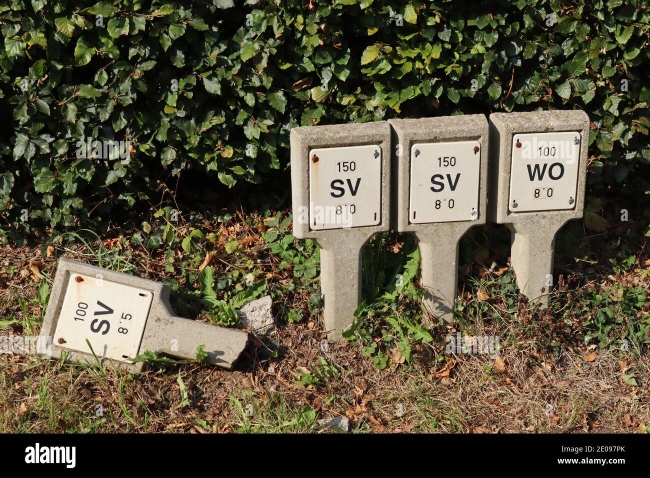 Quatre panneaux en béton sur le bord de la route pour la vanne d'écluse et l'hydratant de lavage. L'un est cassé et est tombé dessus Banque D'Images