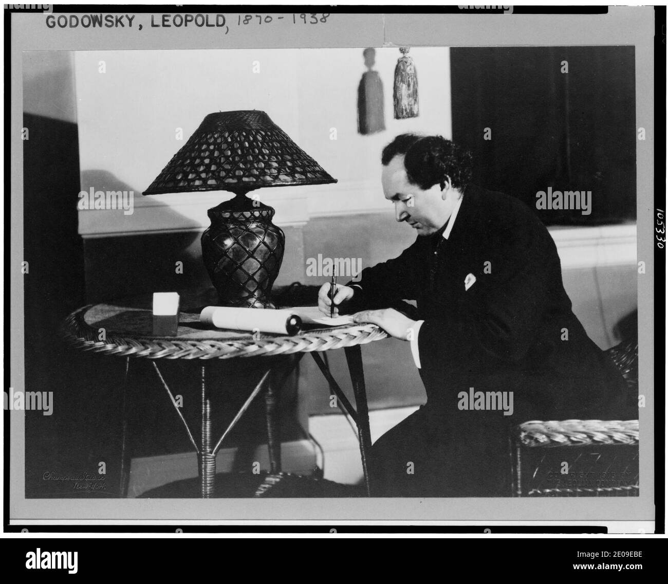 Leopold Godowsky, trois-quarts portrait, assis à table en rotin avec lampe, orienté vers la gauche, de l'écriture Banque D'Images