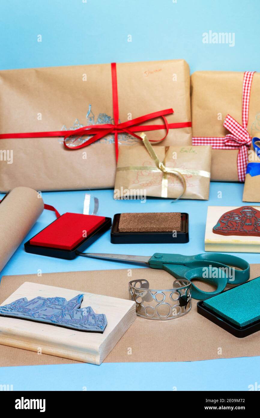 Emballage des cadeaux de Noël dans un environnement convivial avec du  papier brun, des rubans et des timbres Photo Stock - Alamy