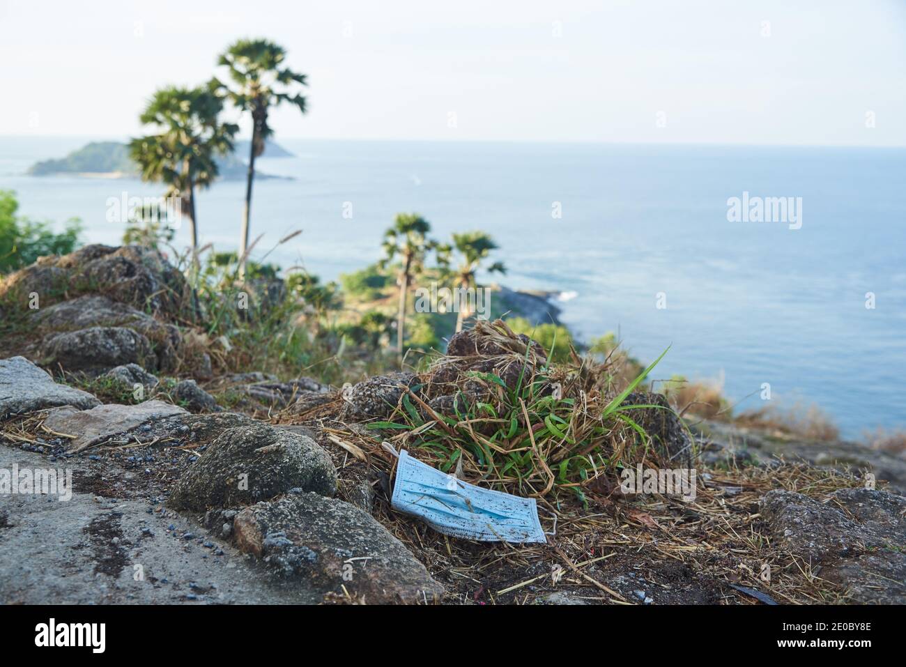 Masque jetable jeté sur le sol au point de vue de Laem Phrom Thep, Phuket, Thaïlande. Banque D'Images