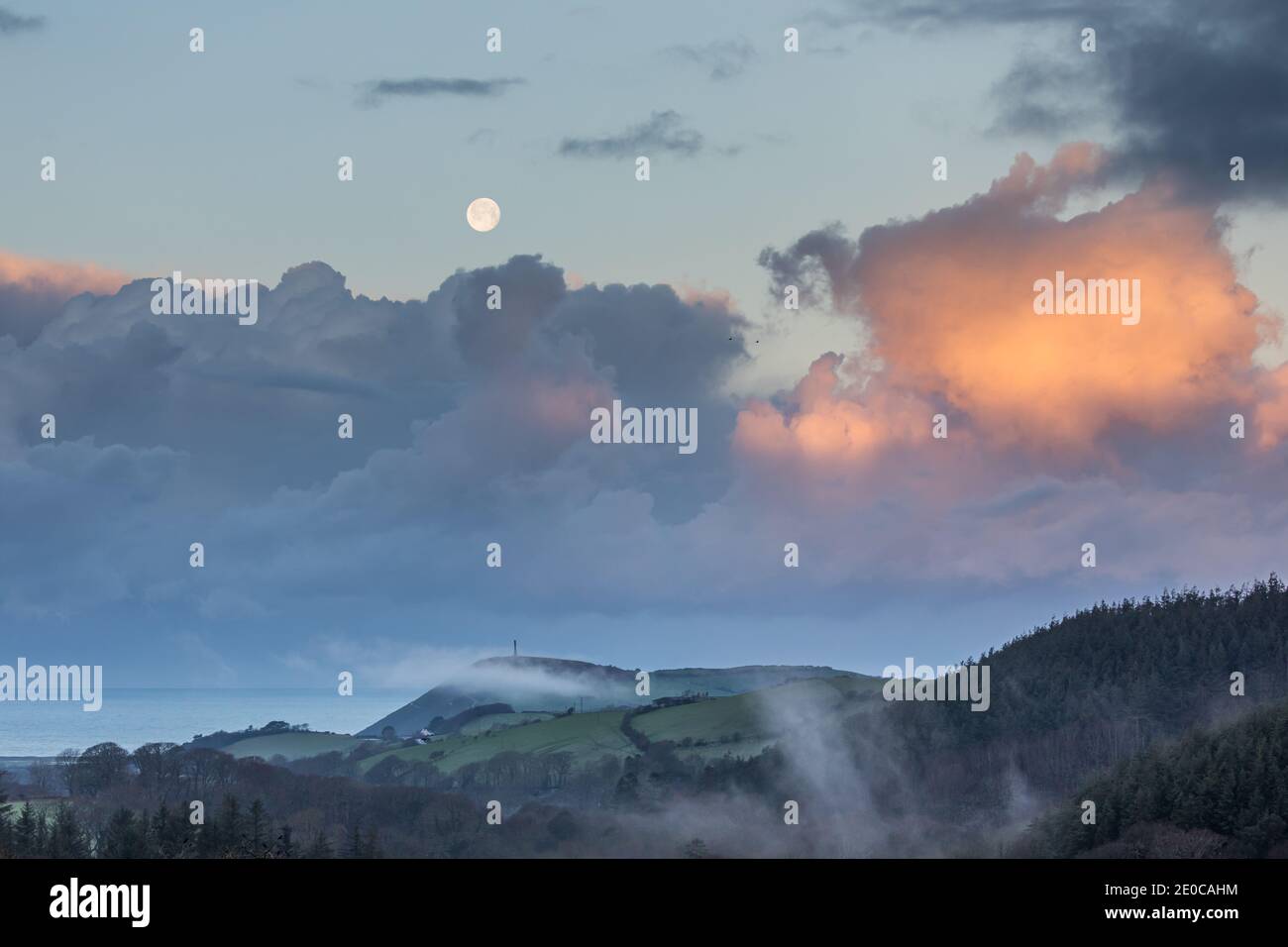 Aberystwyth, Ceredigion, pays de Galles, Royaume-Uni. 31 décembre 2020 Royaume-Uni Météo: Une matinée froide à Aberystwyth alors que la dernière pleine lune en 2020 commence à s'établir, avec le lever du soleil éclairant les zones de la basse couche de nuages au-dessus du monument Pendinas. Tandis que la température chute à moins 1 degré ce matin sur la côte ouest. © Ian Jones/Alamy Live News Banque D'Images