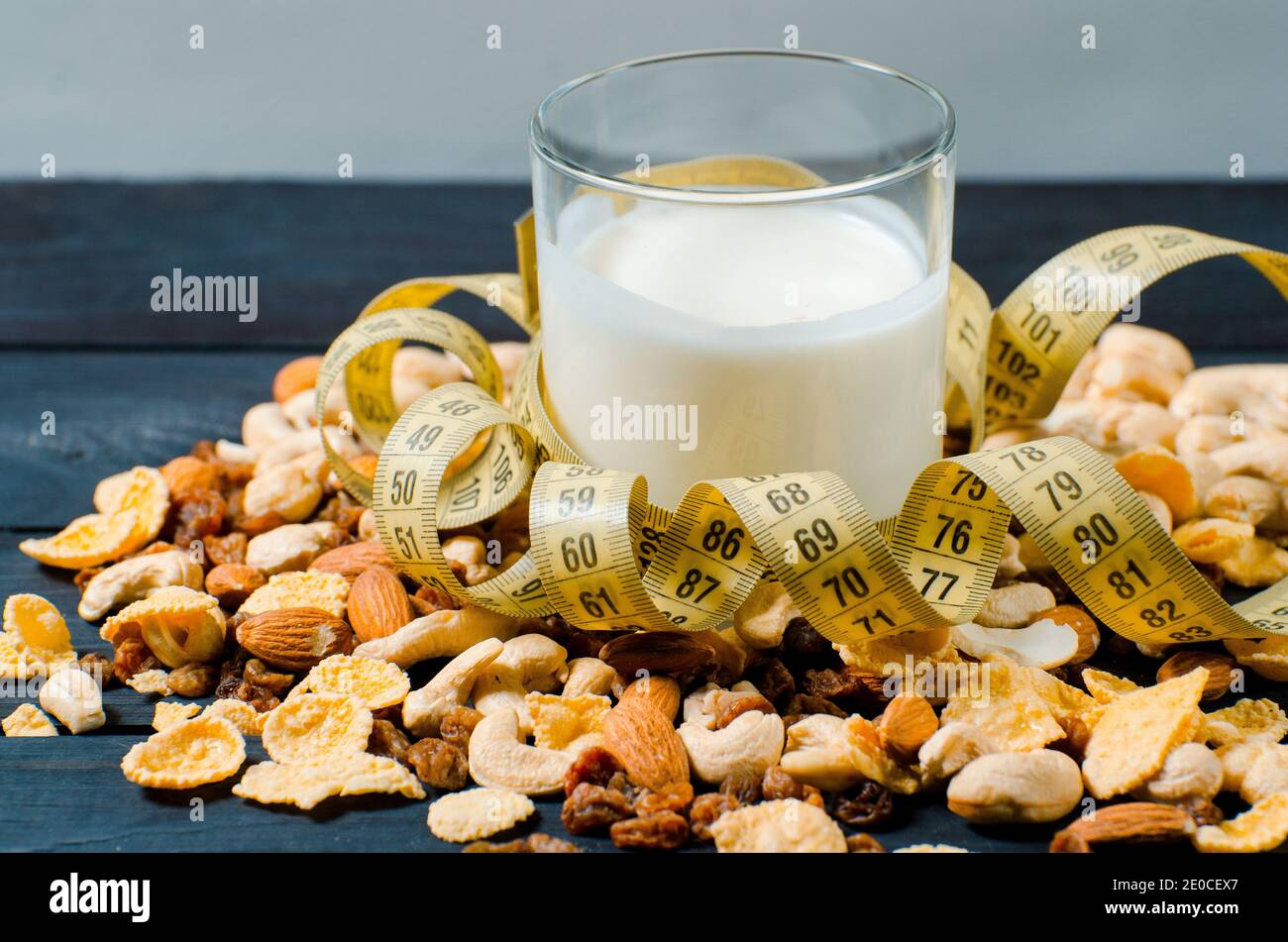 Un mode de vie sain. Dans un verre transparent il y a du lait, sur un fond en bois se trouvent des céréales. Nourriture saine pour la perte de poids Banque D'Images