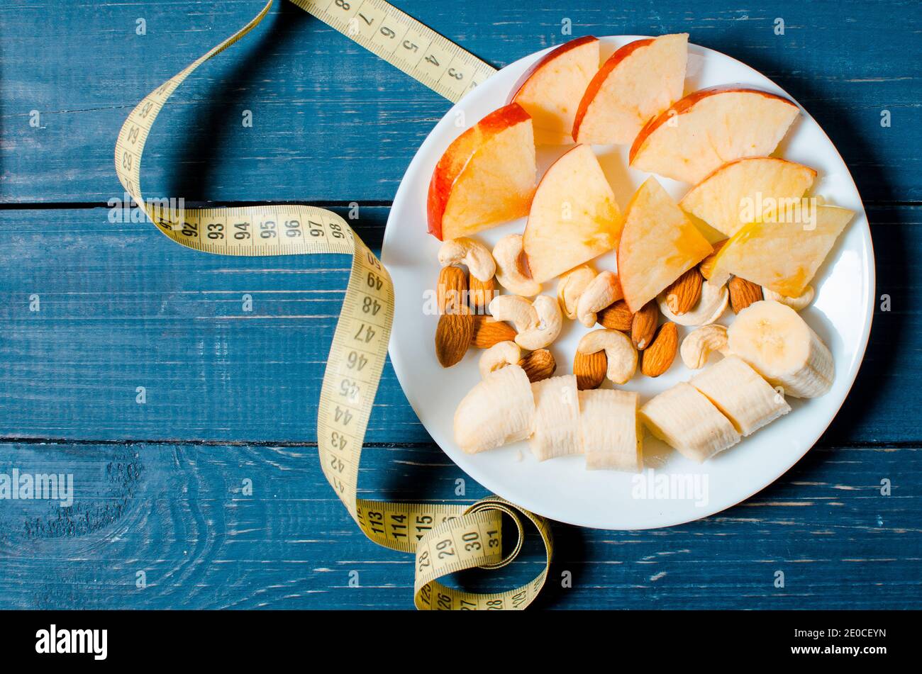 Un mode de vie sain. Pomme et jus d'orange sur fond de bois. Nourriture pour la perte de poids. Céréales. Mètre à ruban. Banque D'Images