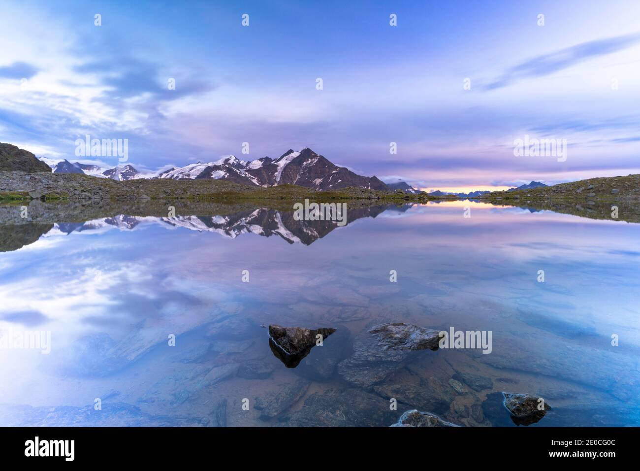 Coucher de soleil sur l'eau claire du lac Manzina avec le sommet de Tresero sur fond, Valfurva, Valtellina, Lombardie, Italie, Europe Banque D'Images
