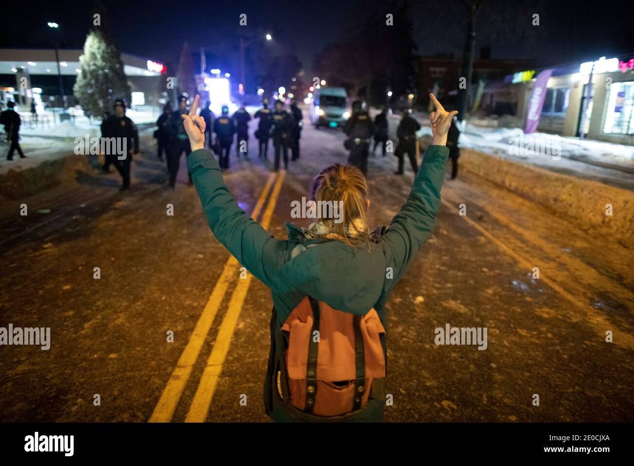 Minneapolis, Minnesota, États-Unis. 31 décembre 2020. Une femme donne deux doigts moyens à la police alors qu'elle s'éloigne des manifestants et quitte la zone où un officier a tiré et tué quelqu'un la veille. La scène de la fusillade était à 1 mile de là où George Floyd a été tué par l'ancien officier Derek Chauvin en mai. Credit: Chris Juhn/ZUMA Wire/Alay Live News Banque D'Images