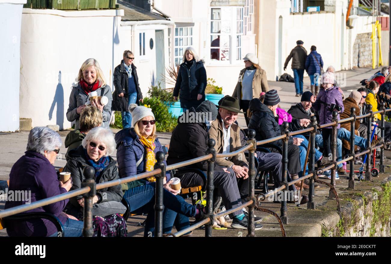 Lyme Regis, Dorset, Royaume-Uni. 31 décembre 2020. Météo au Royaume-Uni : les cafés et les restaurants ferment lorsque la ville entre dans le niveau 3. Les habitants de la région apprécient leur café le matin à l'extérieur, le long du front de mer. Les nouvelles restrictions ont porté un coup supplémentaire aux entreprises d'accueil locales à ce qui devrait être l'une des périodes les plus achalandées de l'année. Credit: Celia McMahon/Alamy Live News Banque D'Images