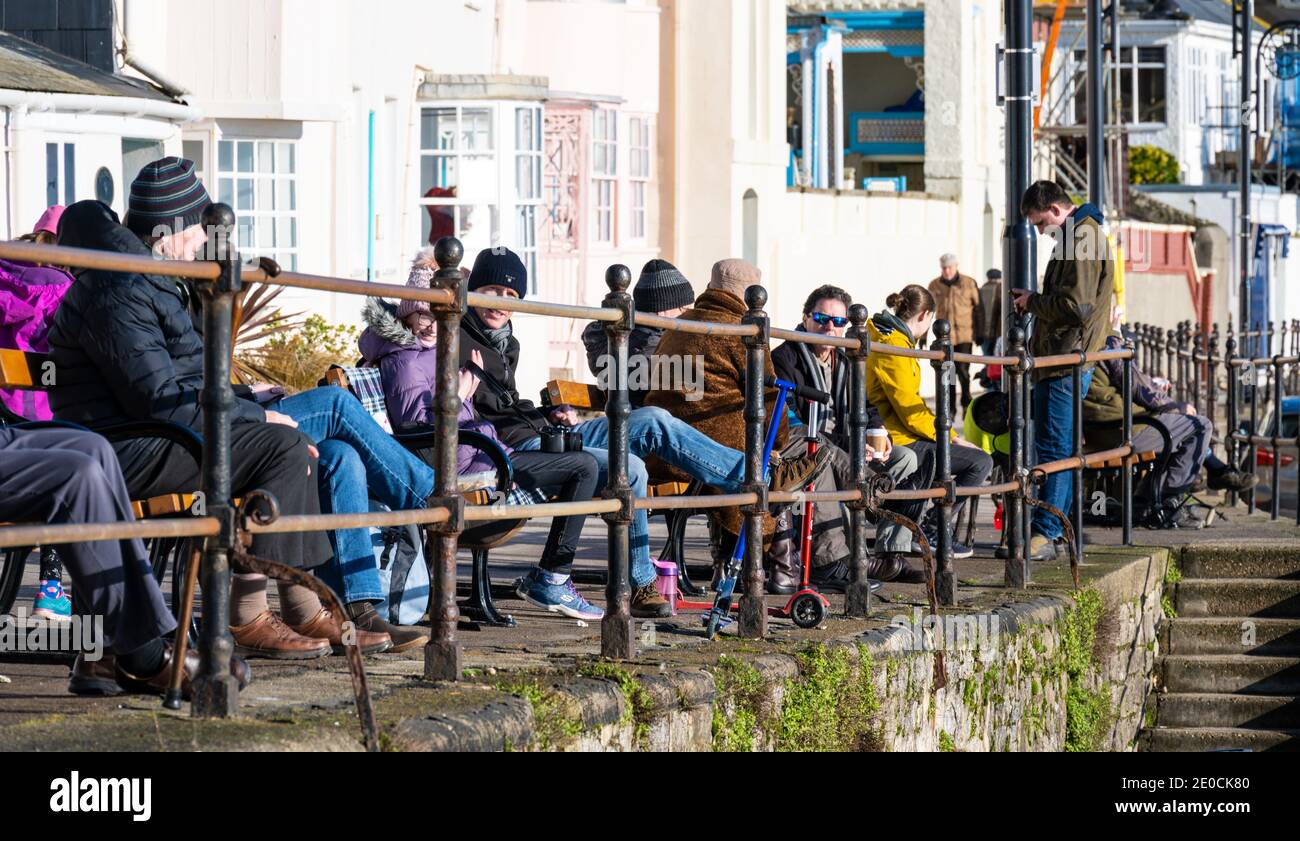 Lyme Regis, Dorset, Royaume-Uni. 31 décembre 2020. Météo au Royaume-Uni : les cafés et les restaurants ferment lorsque la ville entre dans le niveau 3. Les habitants de la région apprécient leur café le matin à l'extérieur, le long du front de mer. Les nouvelles restrictions ont porté un coup supplémentaire aux entreprises d'accueil locales à ce qui devrait être l'une des périodes les plus achalandées de l'année. Credit: Celia McMahon/Alamy Live News Banque D'Images