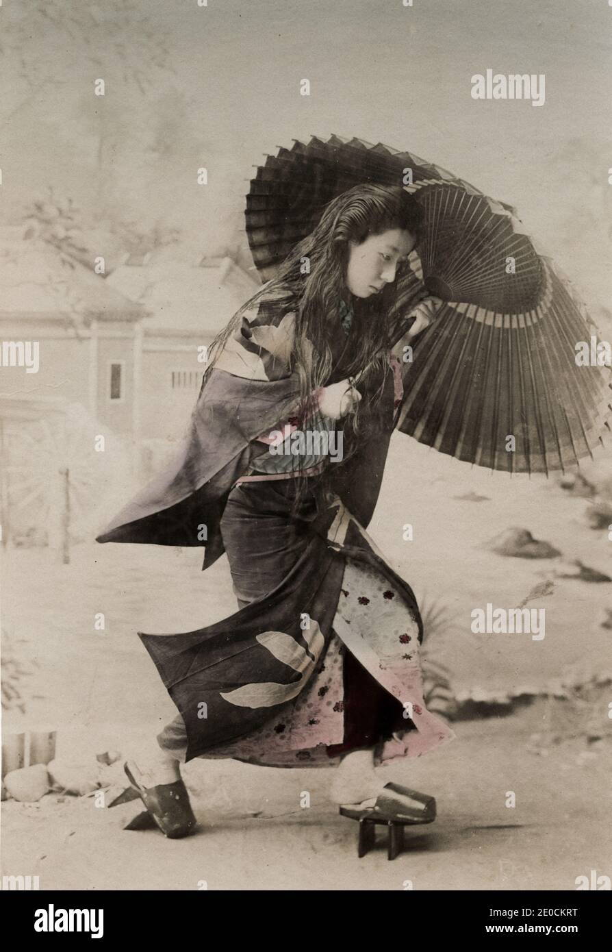 Photographie vintage du XIXe siècle - jeune femme japonaise avec ses cheveux, son parapluie et ses chaussures d'extérieur. Banque D'Images