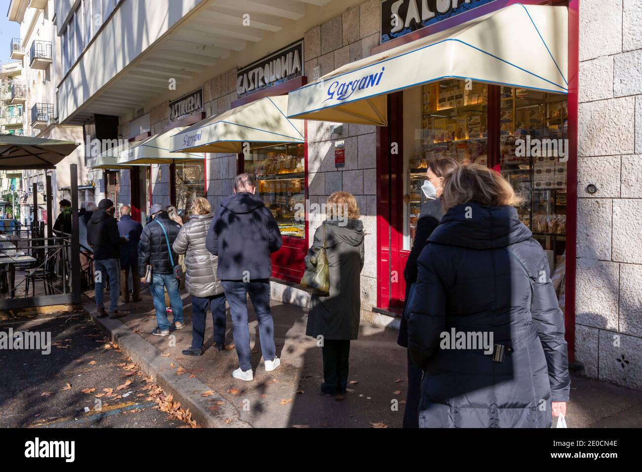 Rome, Italie. 31 décembre 2020. Les acheteurs font la queue devant une épicerie fine dans le quartier Parioli de Rome pour acheter des articles pour le dîner du nouvel an, le « cénone », qui comprend traditionnellement du poisson et des lentilles et parfois un trotter de porc. Les restrictions de la Red zone sont de retour en vigueur du 31 décembre au 3 janvier 2021. En dépit de restrictions sévères limitant le mouvement et permettant l'ouverture de magasins essentiels seulement, beaucoup de gens sont dehors et au sujet de shopping et de marche. Crédit : Stephen Bisgrove/Alay Live News Banque D'Images