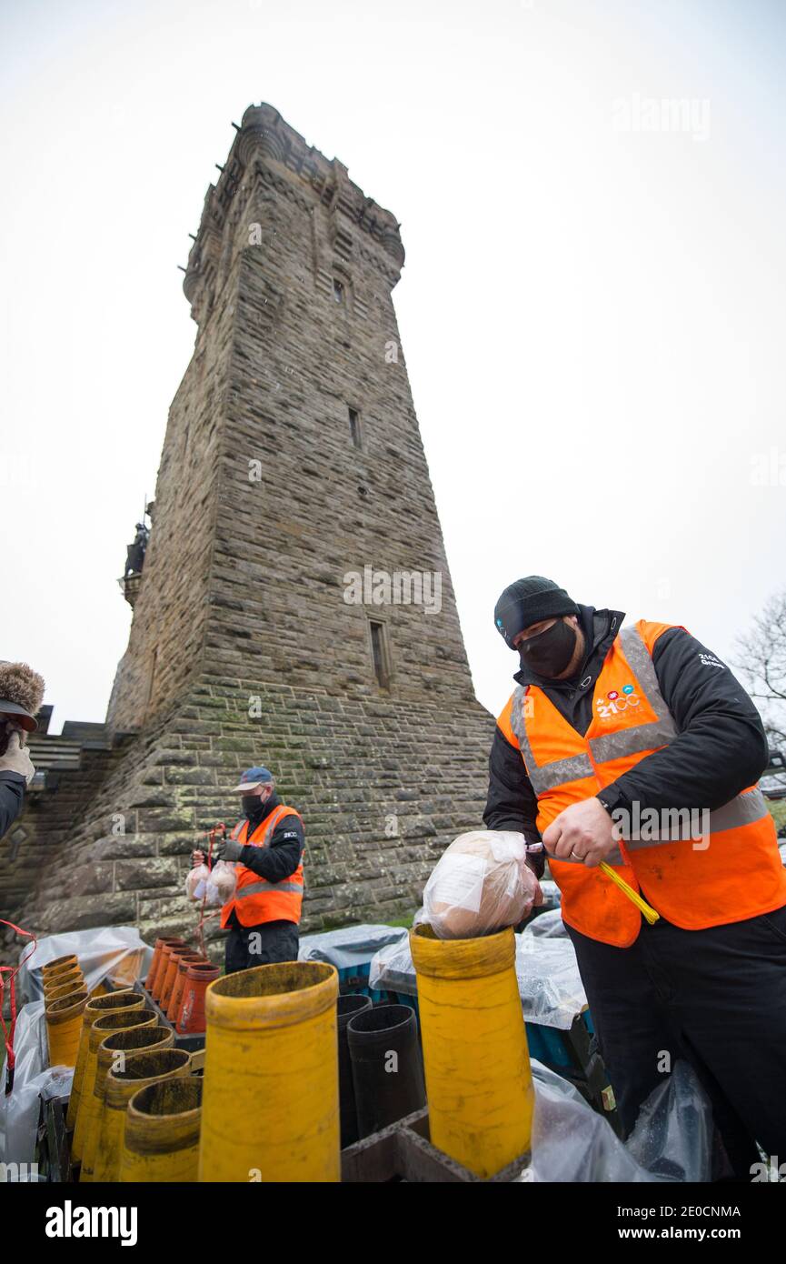 Stirling, Écosse, Royaume-Uni. 31 décembre 2020. Photo : experts pyrotechniques du Monument Wallace. Des experts pyrotechniques de 21CC Fireworks, une société d'événements basée à Édimbourg, chargent soigneusement les obus de mortier dans leurs tubes de lancement alors qu'ils se préparent pour ce soir Hogmanay pyro spectaculaire qui illuminera le ciel à 600 mètres au-dessus du Monument Wallace. Un spectacle de lumière projeté sur la façade du Monument Wallace accompagnera les feux d'artifice. En raison de la pandémie du coronavirus (COVID19), le spectacle sera diffusé en direct à la télévision et en ligne depuis que l'Écosse est en phase 4 verrouillée. Crédit : Colin Fisher Banque D'Images