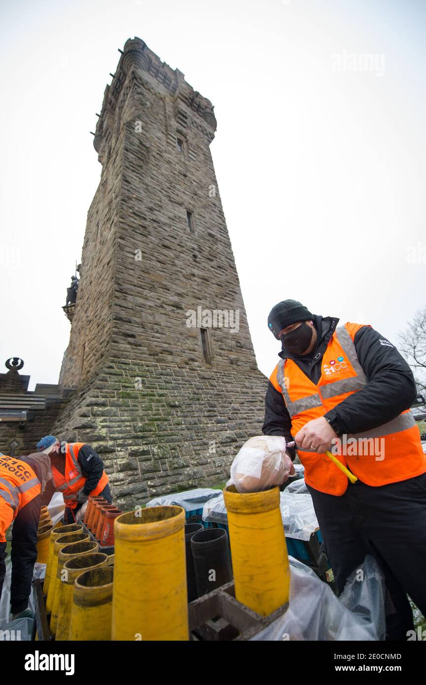 Stirling, Écosse, Royaume-Uni. 31 décembre 2020. Photo : experts pyrotechniques du Monument Wallace. Des experts pyrotechniques de 21CC Fireworks, une société d'événements basée à Édimbourg, chargent soigneusement les obus de mortier dans leurs tubes de lancement alors qu'ils se préparent pour ce soir Hogmanay pyro spectaculaire qui illuminera le ciel à 600 mètres au-dessus du Monument Wallace. Un spectacle de lumière projeté sur la façade du Monument Wallace accompagnera les feux d'artifice. En raison de la pandémie du coronavirus (COVID19), le spectacle sera diffusé en direct à la télévision et en ligne depuis que l'Écosse est en phase 4 verrouillée. Crédit : Colin Fisher Banque D'Images
