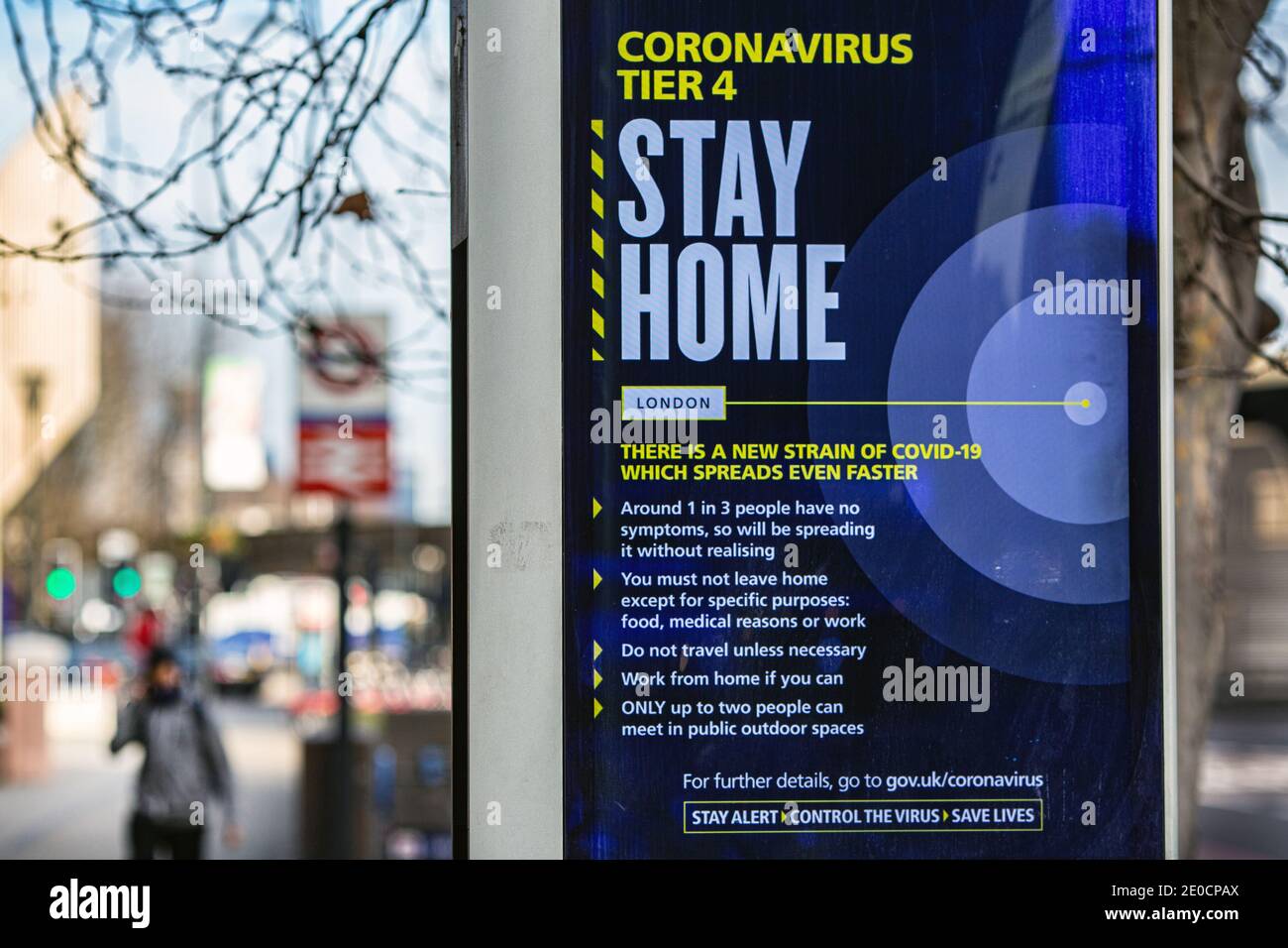 Un homme passe devant un panneau indiquant le coronavirus « Stay Home » à Vauxhall. Londres a été placé sous les restrictions de niveau 4 à mesure que les cas de pointe et de nouvelles souches de COVID- Banque D'Images