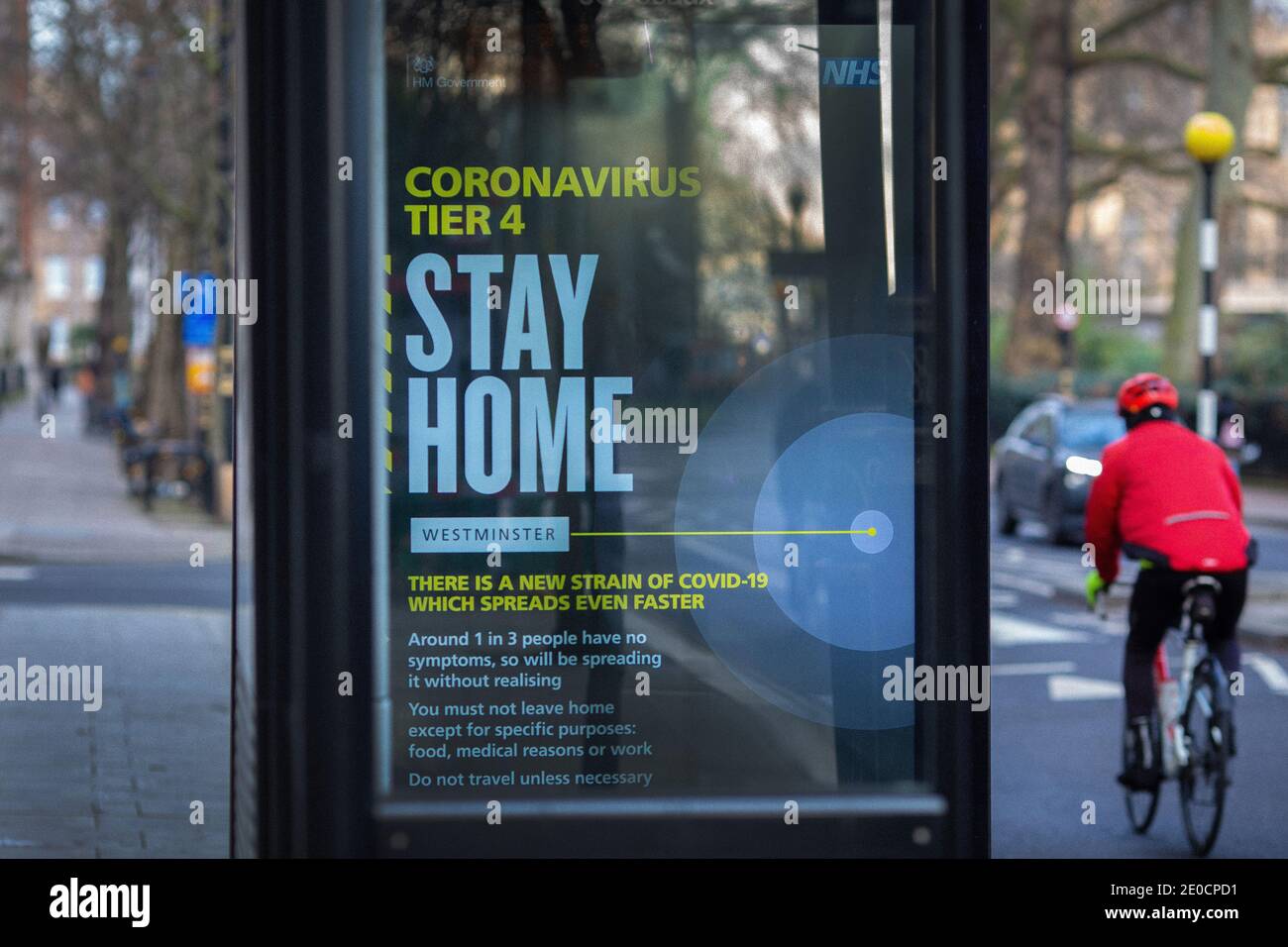 Un homme passant devant un signe de coronavirus 'Stay Home' Westminster.London a été placé sous des restrictions de niveau 4 comme cas Surtension et nouvelles souches de COV Banque D'Images