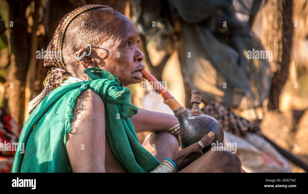 Vieille femme surma, pipe à eau de fumée, vallée d'Omo, Ethiopie Banque D'Images