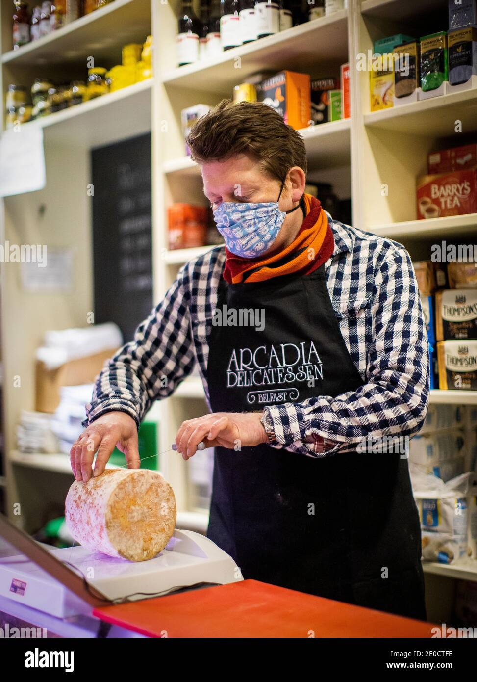 Mark Brown propriétaire de l'Arcadia, un magasin indépendant de fine food à Belfast, coupe dans le camion de stilton bleu produit producteur anglais Colston Bassett. Les fromages britanniques peuvent devenir rares sur les tablettes des épiceries fines d'Irlande du Nord, à moins qu'une offre de fraîcheur ne soit acceptée, a déclaré le propriétaire de l'entreprise. Banque D'Images