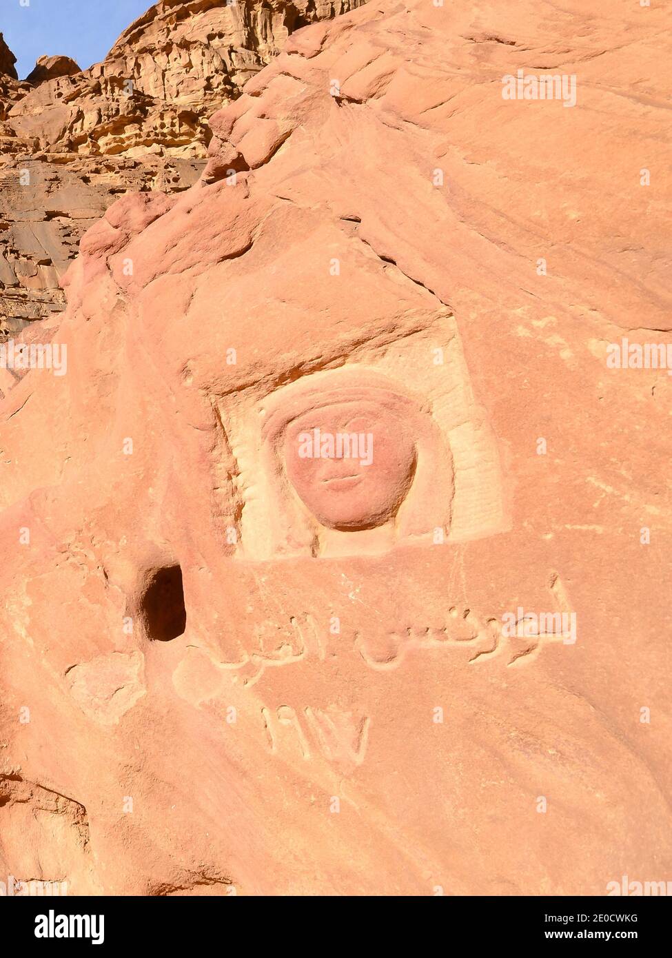 Effigy de T. E. Lawrence sculpté dans la roche dans le désert de Wadi Rum en Jordanie. Lawrence d'Arabie face à la sculpture. Banque D'Images