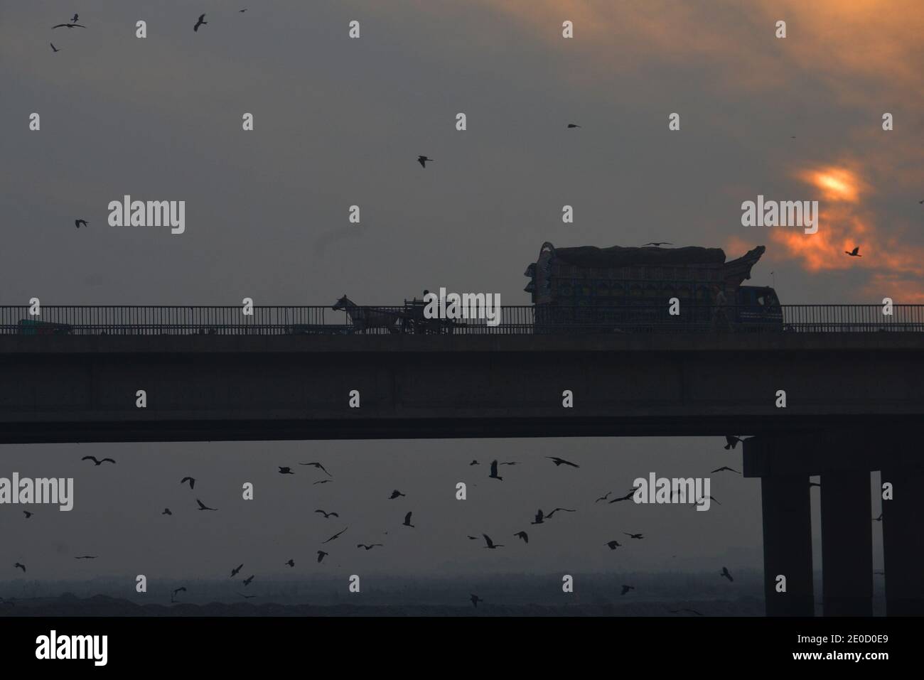 Les Pakistanais sont occupés à travailler de routine au dernier coucher du soleil De l'année 2020 sur le ciel près de la rivière Ravi À Lahore Banque D'Images