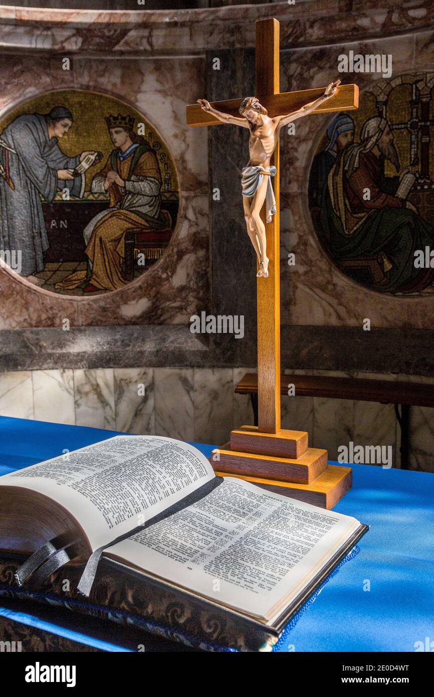 Statue de Jésus-Christ sur une croix avec une bible ouverte à l'intérieur d'une église, représentant la crucifixion Banque D'Images