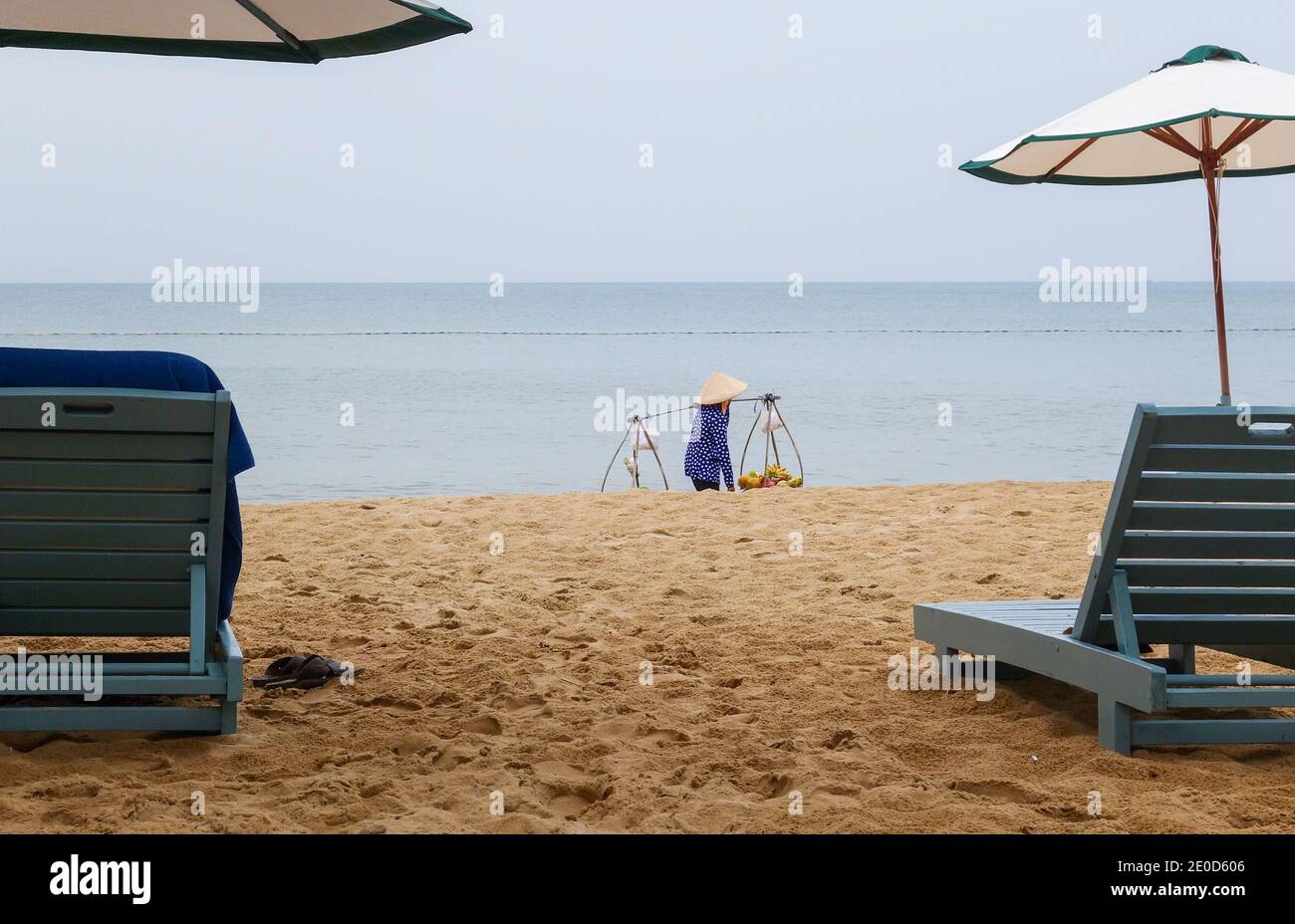 Une femme portant un chapeau conique traditionnel, appelé un non la, vendant des fruits sur la plage à Phu Quoc, Vietnam, Asie Banque D'Images