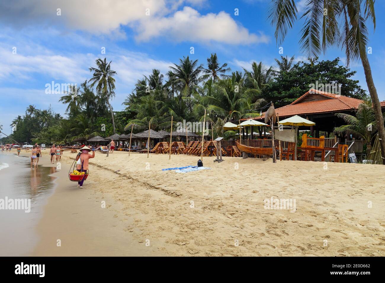Une femme portant un chapeau conique traditionnel, appelé un non la, vendant des fruits sur la plage à Phu Quoc, Vietnam, Asie Banque D'Images