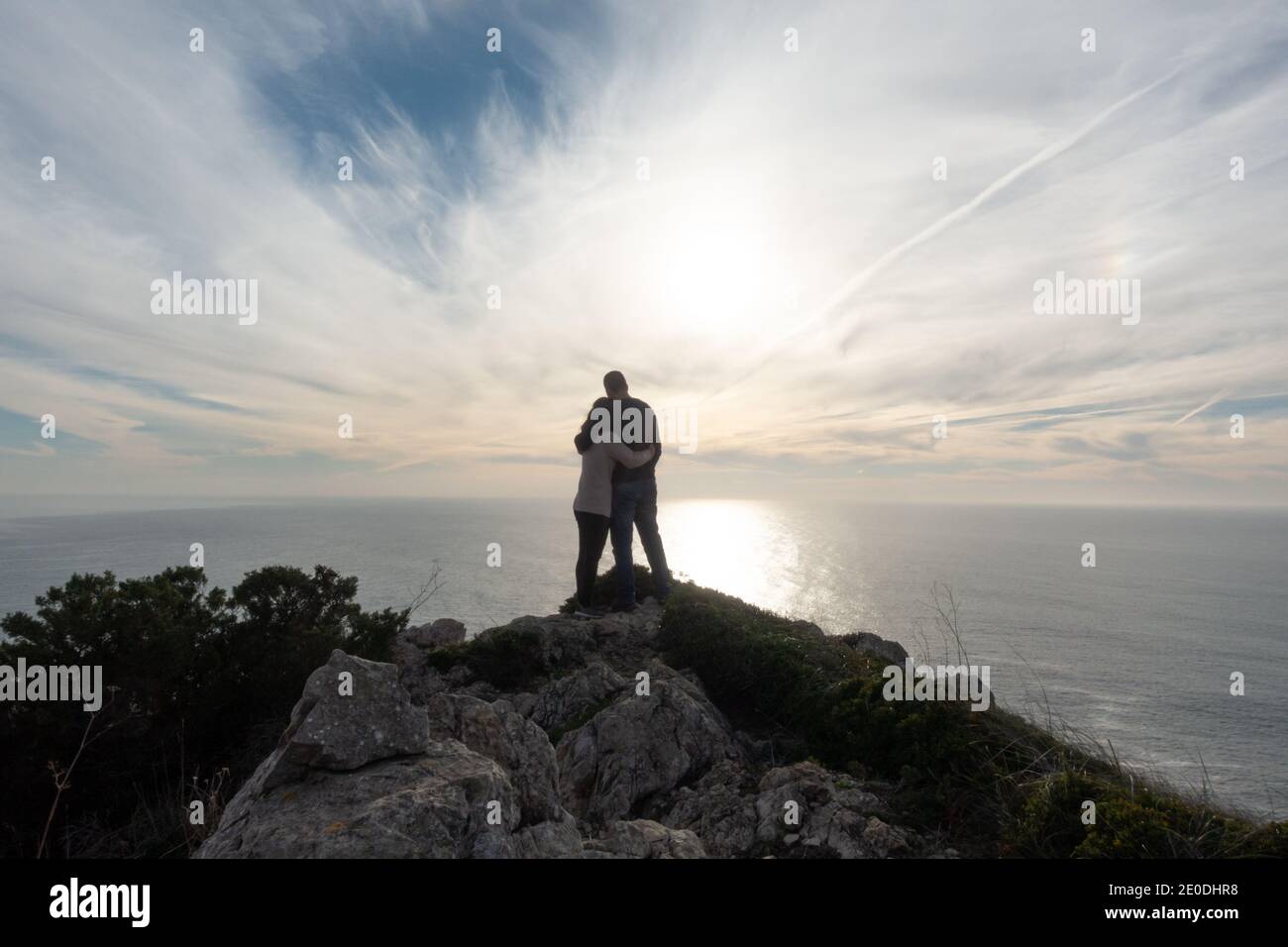 Silhouette de couple romantique tenant un écheveau à une falaise dans le Cap de Cabo Espichel avec l'océan atlantique sur le fond, au Portugal Banque D'Images