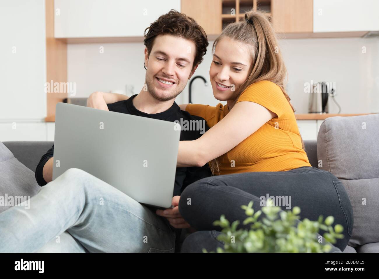 Couple utilisant Internet à domicile rapide avec ordinateur portable. Femme et homme sur canapé dans le salon Banque D'Images