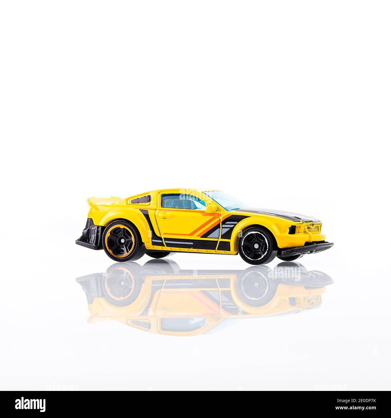 Voiture jaune miniature sur fond blanc et avec réflexion.image prise dans un environnement non contrôlé par flash. Banque D'Images