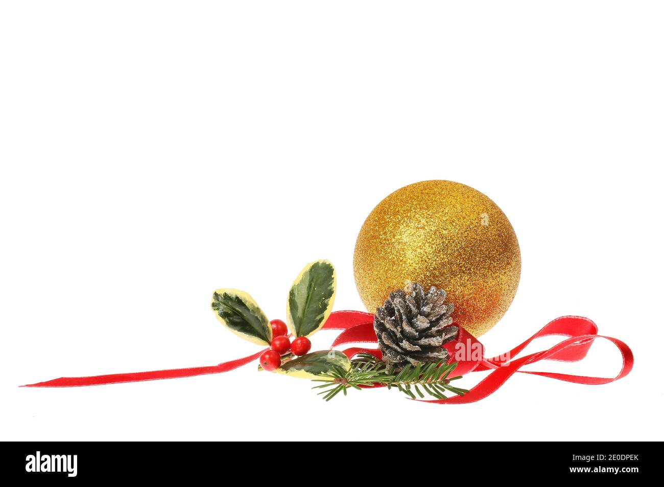 Décoration de Noël, boule dorée à paillettes avec feuillage de saison et ruban rouge spiralé isolé du blanc Banque D'Images