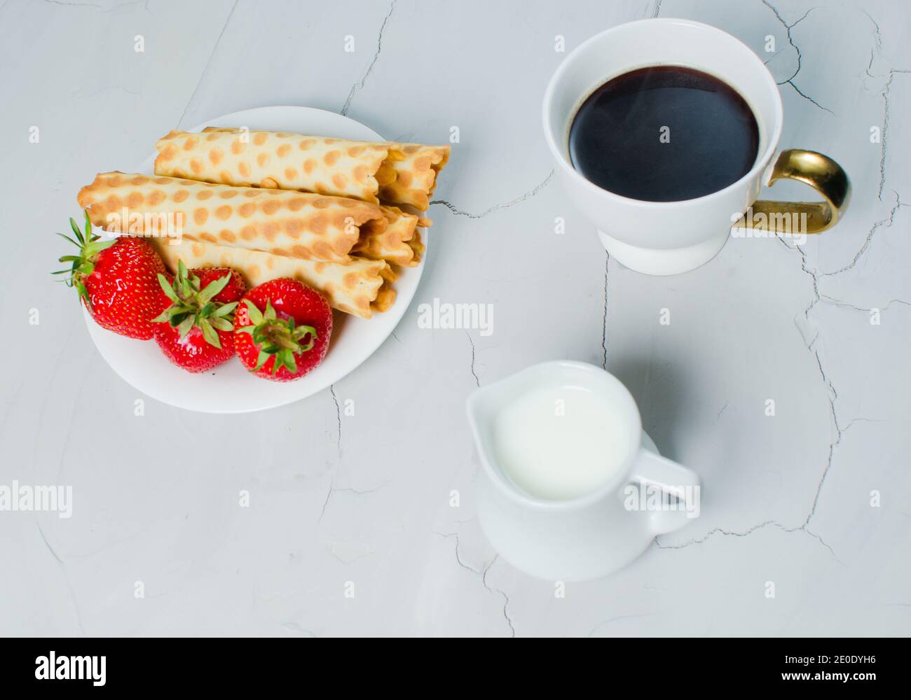 Sur la table se trouve le café chaud, la crème et le dessert sucré avec des fraises fraîches Banque D'Images