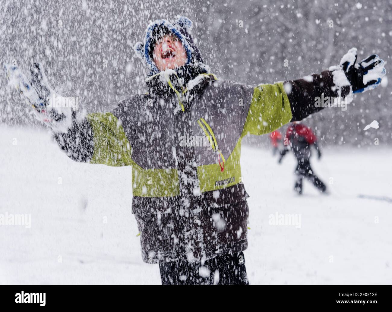 Portrait d'un jeune garçon (8 ans) à l'extérieur dans la neige qui tombe au Québec, Canada Banque D'Images