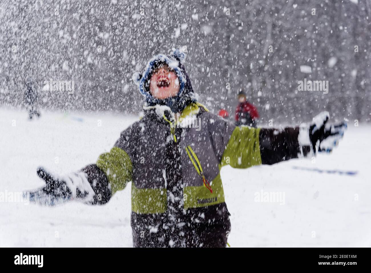 Portrait d'un jeune garçon (8 ans) à l'extérieur dans la neige qui tombe au Québec, Canada Banque D'Images
