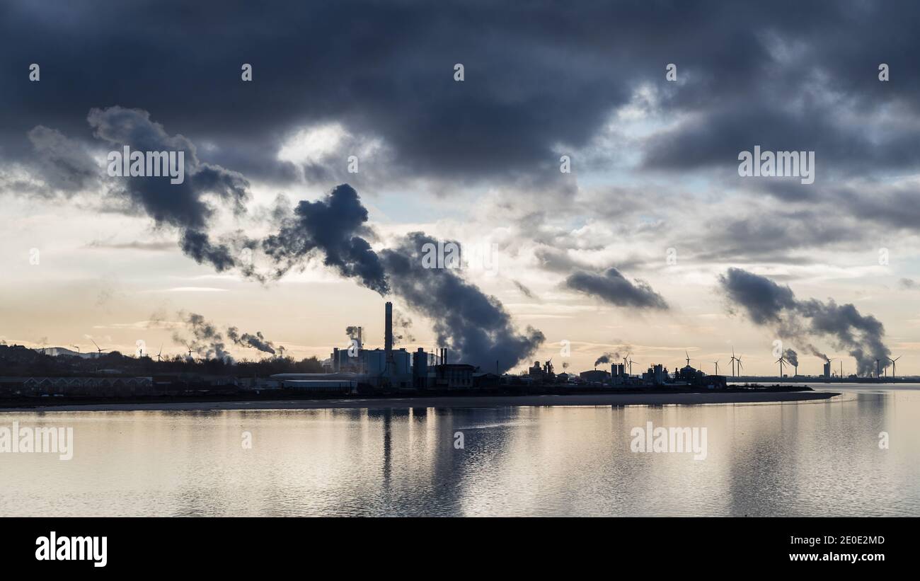 Le canal de Manchester Ship passe un coin industriel de l'estuaire de Mersey un hiver en décembre 2020 sous un ciel sombre. Banque D'Images