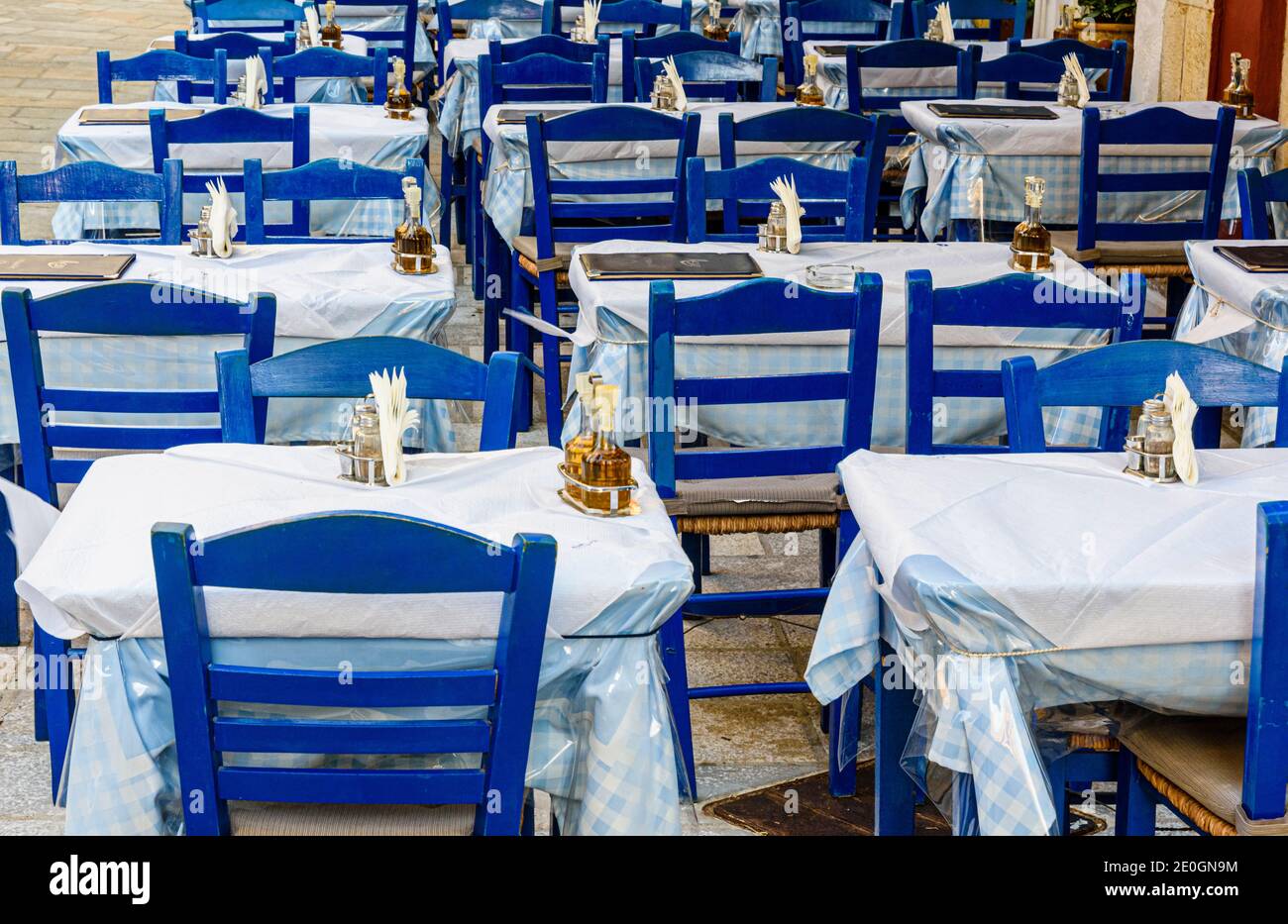 Tables de tavernes grecques vides et chaises bleues Banque D'Images