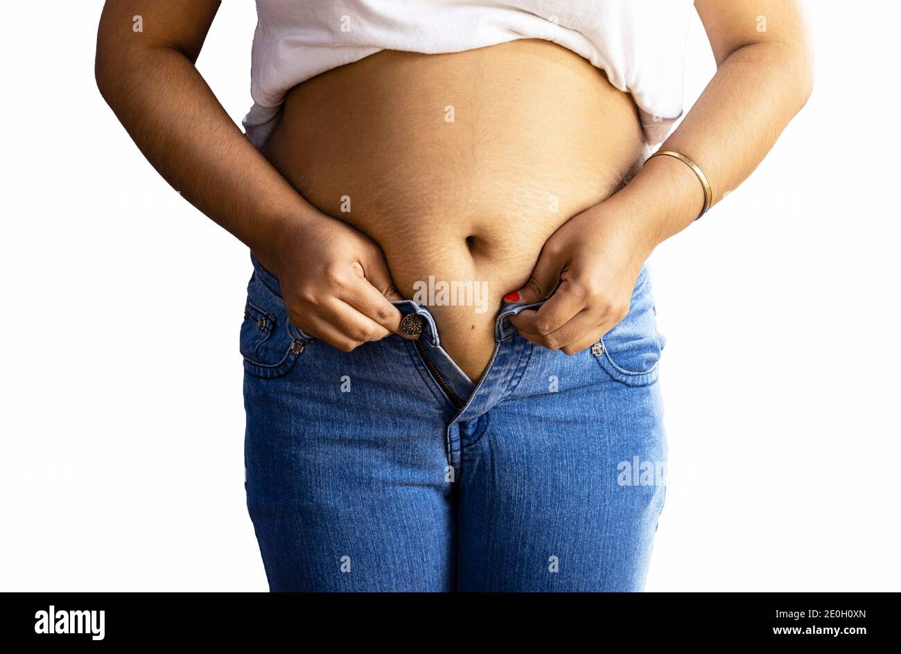 section moyenne d'une femme indienne avec la graisse du ventre portant jeans bleus sur fond blanc Banque D'Images