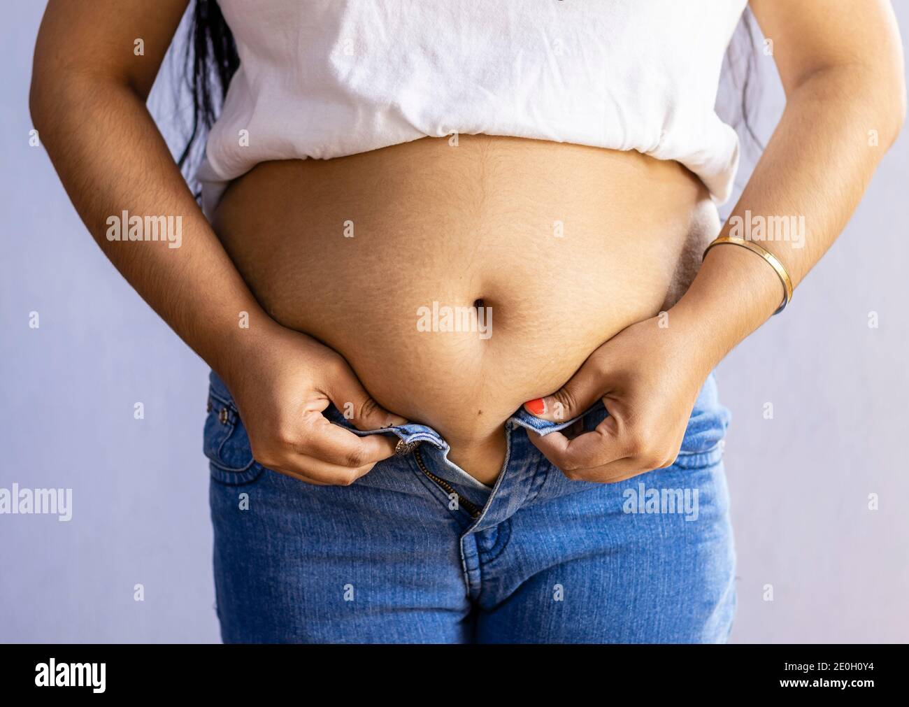 section moyenne d'une femme indienne avec la graisse du ventre portant jeans bleus Banque D'Images