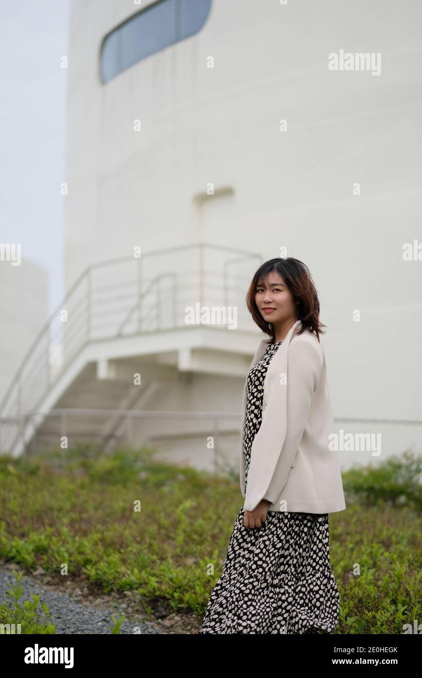 Photo d'une belle jeune femme asiatique souriante à l'extérieur Banque D'Images