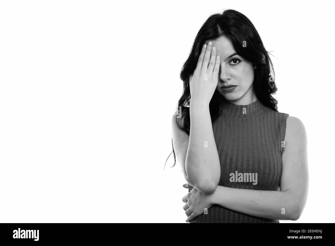 Studio shot of young Beautiful woman covering face tandis que l'espagnol à l'accent sur Banque D'Images