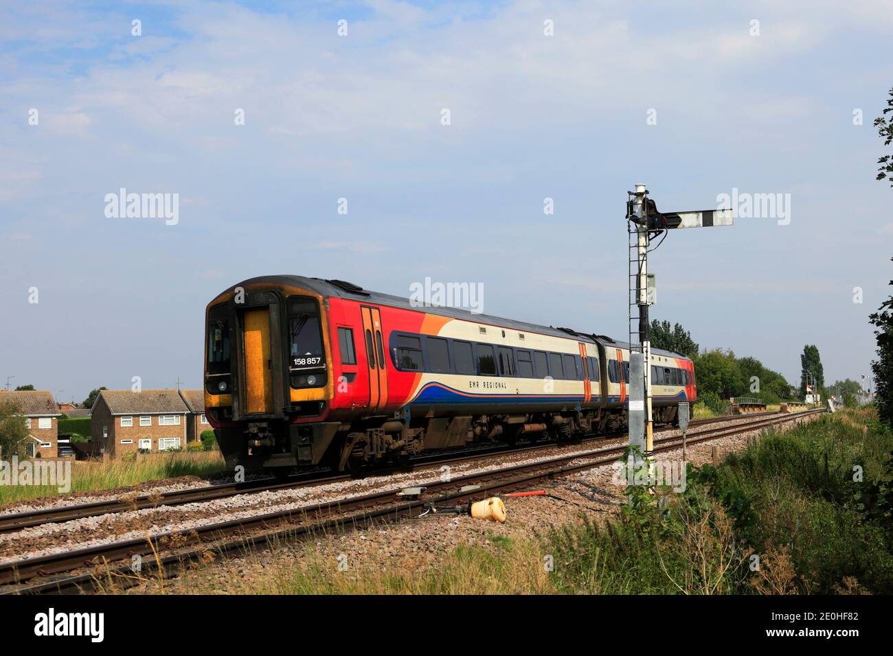 East Midlands Railway train régional 158 857 passant un signal de Semaphore, ville de Whittlesey, Fenland, Cambridgeshire, Angleterre Banque D'Images