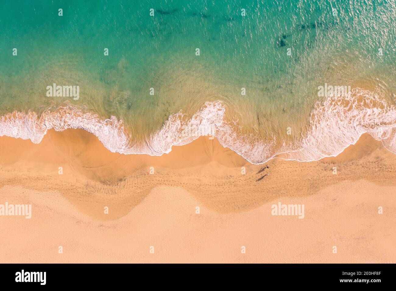 Vue aérienne de haut en bas de la magnifique côte atlantique de l'océan avec des eaux turquoise cristallines et une plage de sable, des vagues se déroulant dans le rivage Banque D'Images