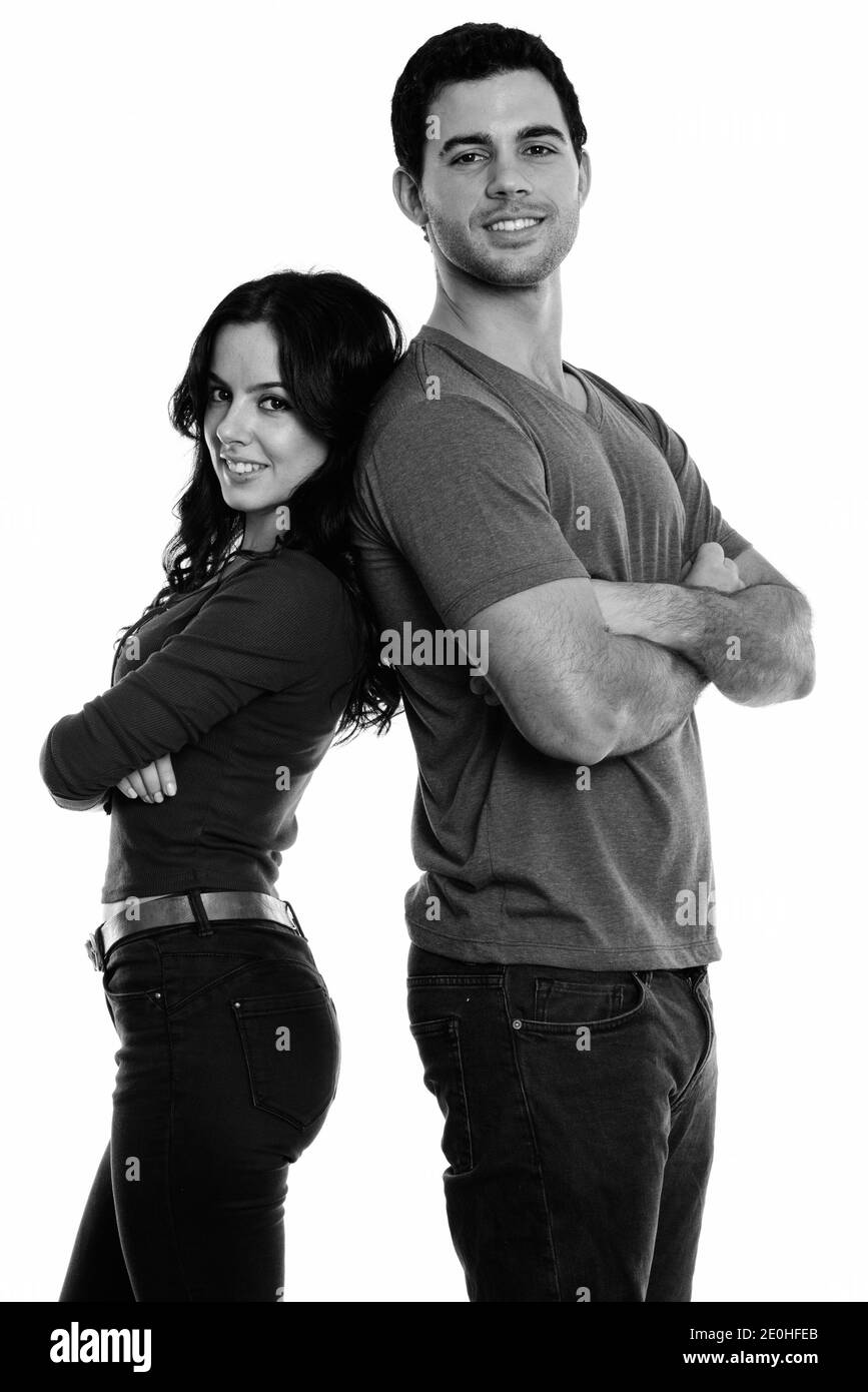Studio shot of young woman smiling with arms crossed avec dos à dos Banque D'Images