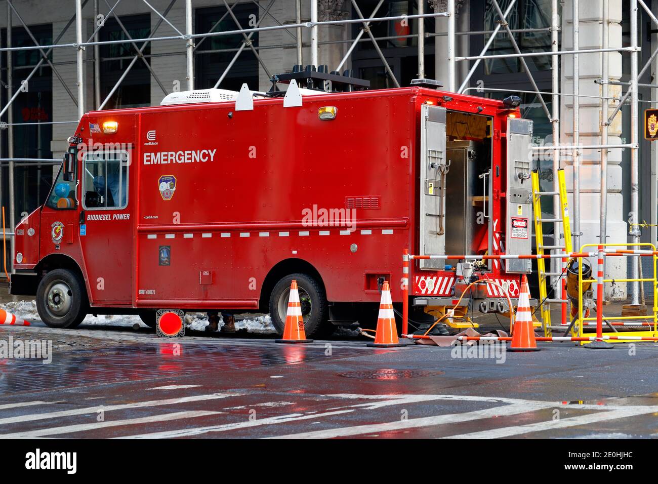 Un camion rouge de réparation d'urgence con Edison dans un trou d'homme de service dans le quartier SoHo de Manhattan, New York, NY. Banque D'Images