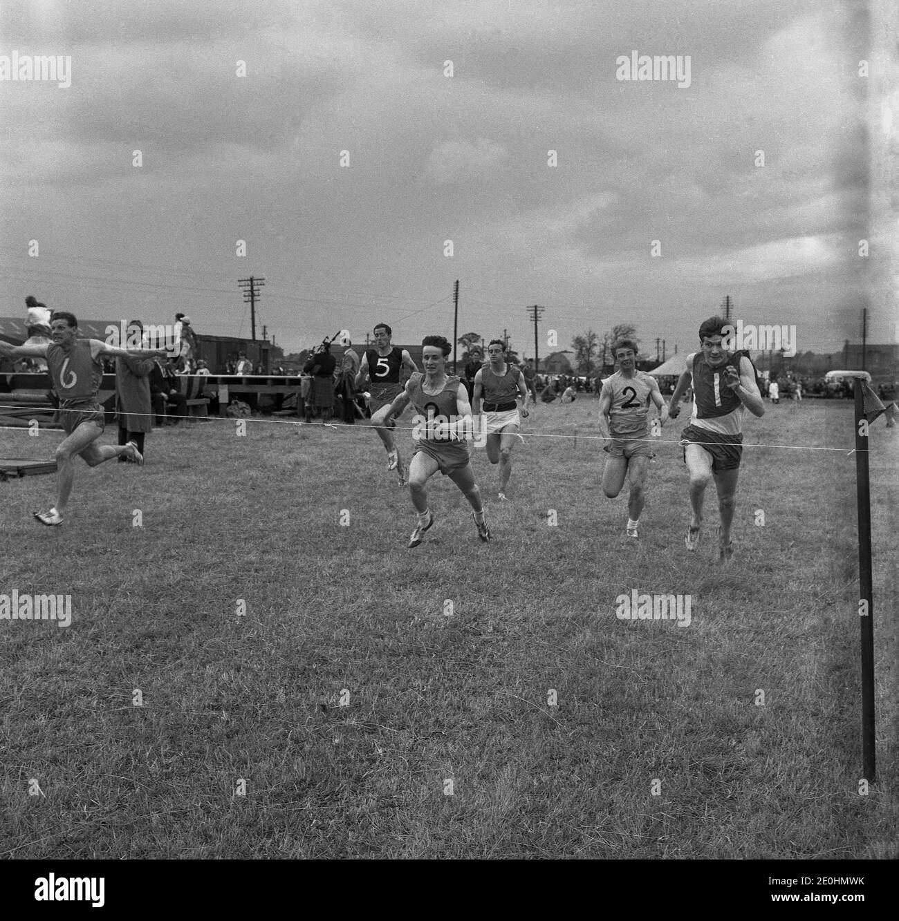 Années 1960, course à pied historique aux Highand Games, Écosse, Royaume-Uni, athlètes masculins en compétition pour la ligne d'arrivée. Banque D'Images