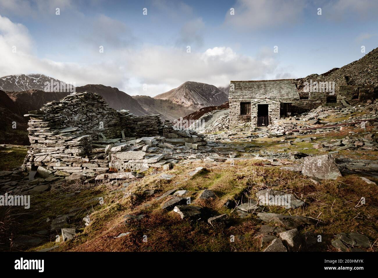 Les coquillages de Lakeland en arrière-plan surplombent le vieux bâtiment et les débris À la mine d'ardoise Honister sur les pentes de Fleetwith Pike Dans le district de English Lake Banque D'Images