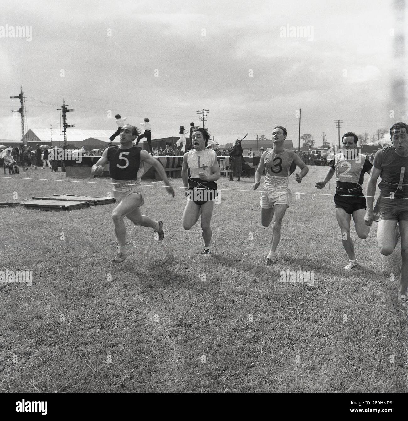 Années 1960, course à pied historique aux Highand Games, Écosse, Royaume-Uni, athlètes masculins en compétition pour la ligne d'arrivée. Banque D'Images